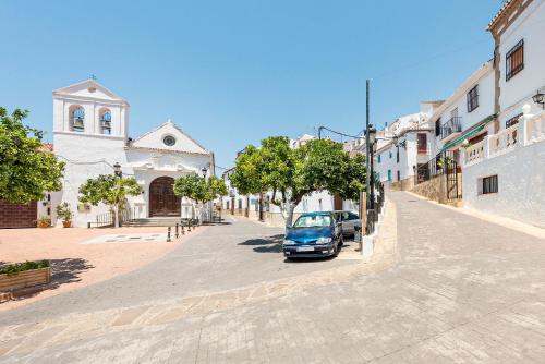 a small car parked on the side of a street at Casa Bonita Residencia in Alcaucín