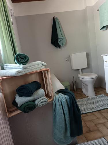 a bathroom with a pile of towels and a toilet at Haus Bernkogel in Sankt Johann im Pongau
