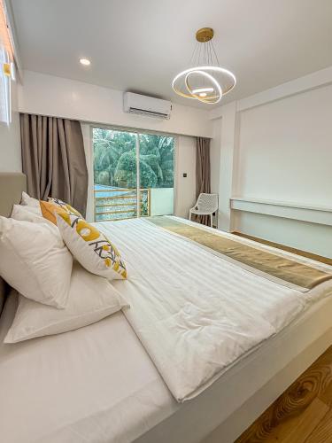 a large white bed in a room with a window at Avenly Omadhoo in Omadhoo