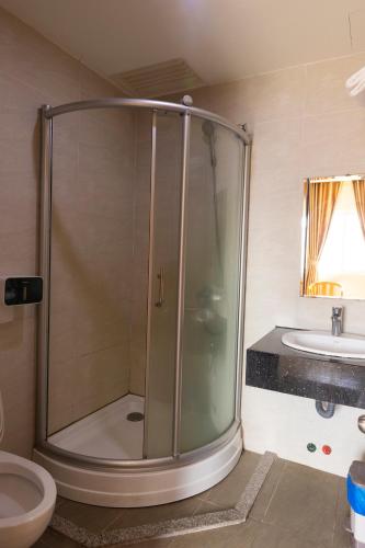 a bathroom with a shower and a toilet and a sink at California Saigon Hotel in Ho Chi Minh City