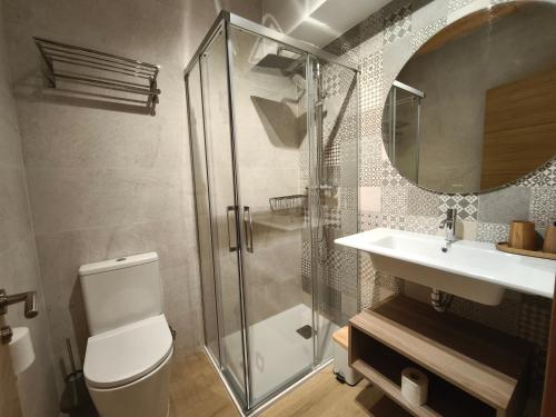 a bathroom with a shower and a toilet and a sink at La Casa de La Villa by Casas de Los Picos in Panes