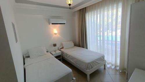 een hotelkamer met twee bedden en een raam bij Baba View Apart in Fethiye
