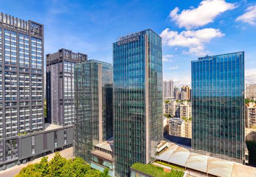 a group of tall glass buildings in a city at Citadines Gongbei Zhuhai in Zhuhai
