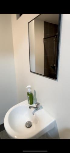 a bathroom sink with a mirror and a soap dispenser on it at Davao Condo Near Airport & Malls in Davao City