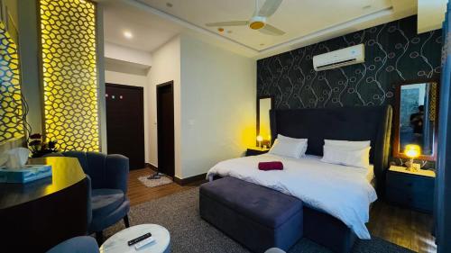 une chambre avec un lit, un canapé et une chaise dans l'établissement Executive 1BHK with Scenic Balcony View & Free Netflix, à Rawalpindi