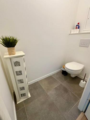 La salle de bains est pourvue de toilettes et d'une table avec une plante. dans l'établissement Appartement standing Vue panoramique sur Nantes, à Nantes