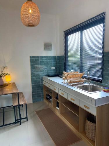 a kitchen with a sink and a window at Green & Pink Garden Homes in Ko Phangan