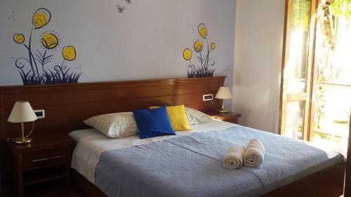 a bedroom with a bed with two pairs of slippers on it at Guest House Međine in Mlini