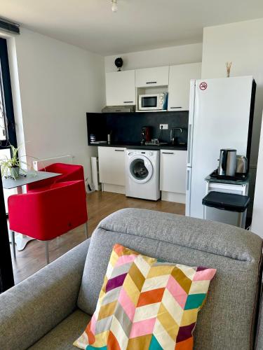 un salon avec un canapé et une cuisine dans l'établissement Appartement standing Vue panoramique sur Nantes, à Nantes
