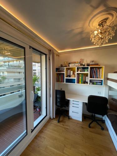 un bureau avec un bureau, deux chaises et une fenêtre dans l'établissement Appartement Belle Feuille, à Boulogne-Billancourt