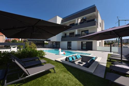 a backyard with a swimming pool and a house at FUX LUXURY Infinty-Pool Zadar in Zadar