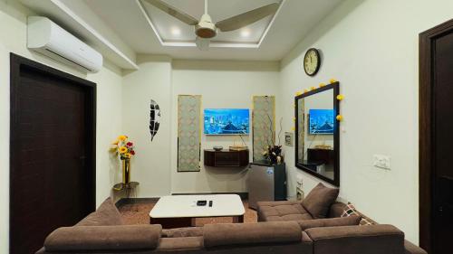 un salon avec un canapé et une table dans l'établissement Executive 1BHK with Scenic Balcony View & Free Netflix, à Rawalpindi