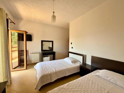 a bedroom with two beds and a mirror at Hotel Horizont in Kuçovë