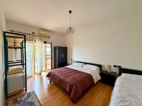 a bedroom with a large bed and a large window at Hotel Horizont in Kuçovë