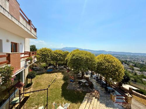 an apartment balcony with a view of a garden at Hotel Horizont in Kuçovë