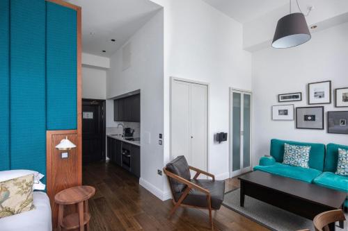 a living room with a blue couch and a table at The Edinburgh Grand, a Luxury Collection Hotel, Edinburgh in Edinburgh
