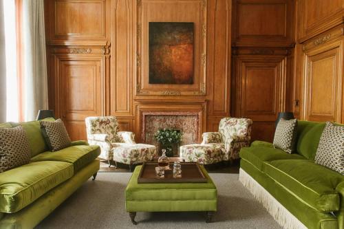 a living room with green couches and a table at The Edinburgh Grand, a Luxury Collection Hotel, Edinburgh in Edinburgh