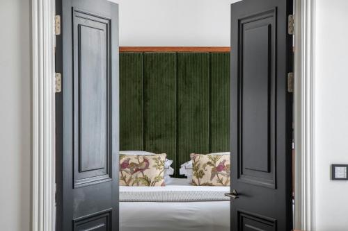 a bedroom with a bed with a green headboard at The Edinburgh Grand, a Luxury Collection Hotel, Edinburgh in Edinburgh