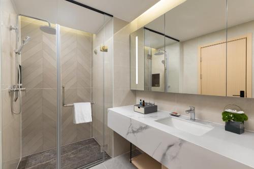 a bathroom with a sink and a shower at Citadines Gongbei Zhuhai in Zhuhai