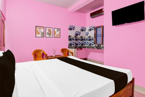 a pink bedroom with a bed and a tv at Hotel O Dream Palace in Chandaka