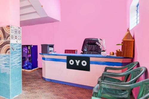 a salon with pink walls and a counter with chairs at Hotel O Dream Palace in Chandaka