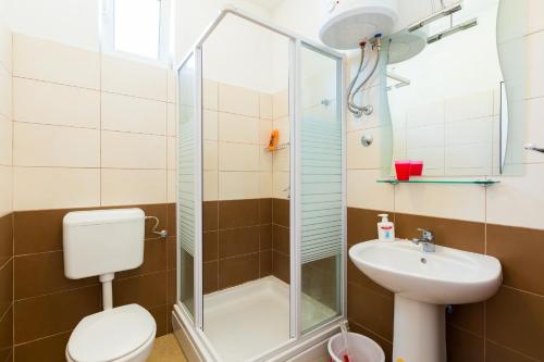 a bathroom with a shower and a toilet and a sink at Studios Tonina in Zaton