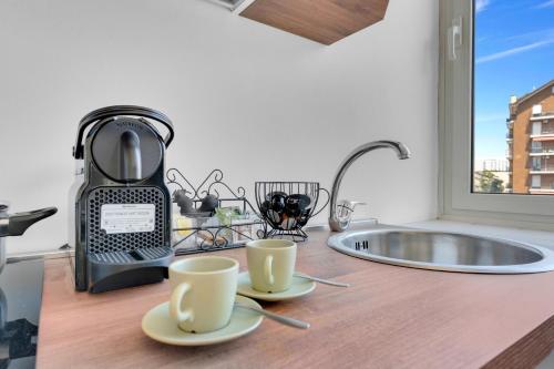 una cucina con due tazze di caffè su un bancone di Navigli - Porta Ticinese - Luminoso monolocale a Milano