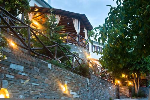 a brick wall with lights on top of it at Iliovolo Guesthouse in Miléai