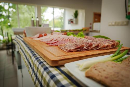 a bunch of meat on a cutting board on a table at Arcus Premium Hostel in Warsaw