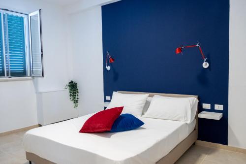 a bedroom with a blue wall and a bed with two pillows at Castellinaria Holiday in Castellana Grotte