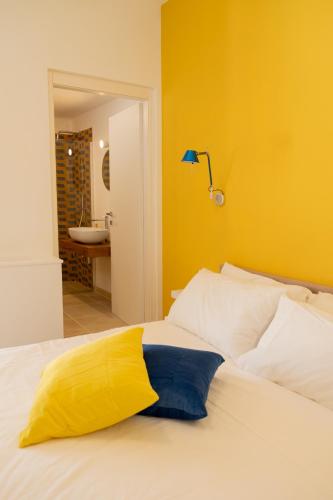 a bedroom with a bed with a yellow wall at Castellinaria Holiday in Castellana Grotte