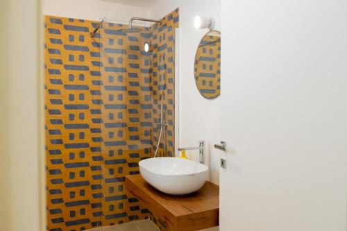 a bathroom with a bowl sink on a wooden counter at Castellinaria Holiday in Castellana Grotte