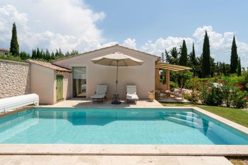 - une piscine avec un parasol à côté d'une maison dans l'établissement Lou Cigaloun, à Bédoin