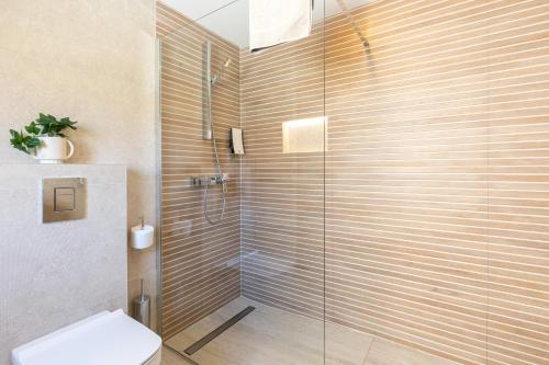 a bathroom with a glass shower with a toilet at Villa Peragro in Dubrovnik