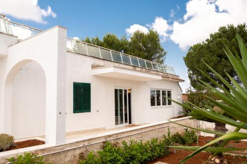 a white house with solar panels on the roof at Castellinaria Holiday in Castellana Grotte