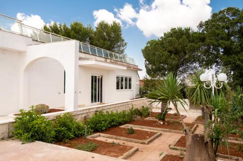 a white house with trees and plants at Castellinaria Holiday in Castellana Grotte