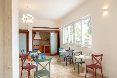 a dining room with tables and chairs and a window at Castellinaria Holiday in Castellana Grotte