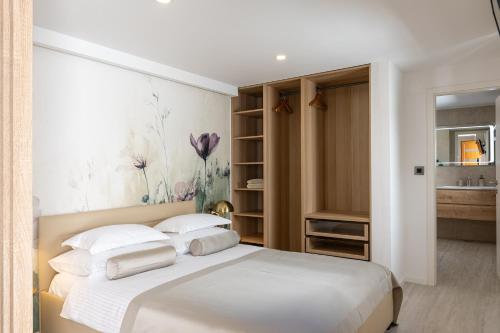 a bedroom with a white bed with white pillows at Villa Peragro in Dubrovnik
