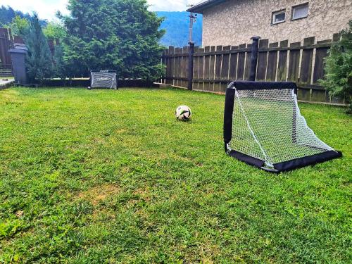 a dog laying on the grass next to a goal at Chata pri Kaštieli in Necpaly