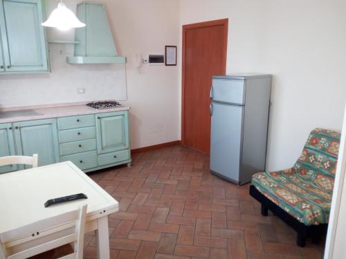 a kitchen with a refrigerator and a table and a chair at BB Mambrotta in San Martino Buon Albergo