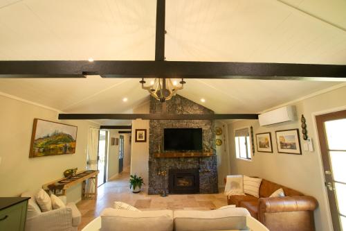 a living room with a couch and a fireplace at Ceffyl Cottage in Gheerulla