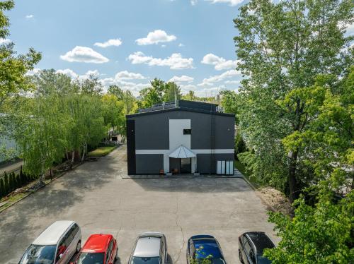 a small black building with a white cross on it in a parking lot at Arcus Premium Hostel in Warsaw