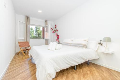 a white bedroom with a large white bed and a window at Milenial Immo Marignane - Apartment 500m Dalí Figueres in Figueres