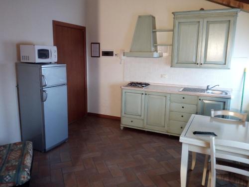 a kitchen with a refrigerator and a table and a microwave at BB Mambrotta in San Martino Buon Albergo