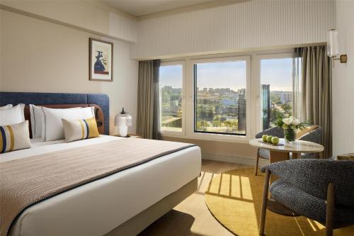 a hotel room with a large bed and a window at Tivoli Oriente Lisboa Hotel in Lisbon