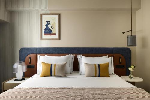 une chambre avec un grand lit avec une tête de lit bleue dans l'établissement Tivoli Oriente Lisboa Hotel, à Lisbonne