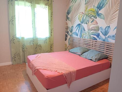 a bedroom with a bed with pink sheets and a window at Chez Lulu, au pied de la Dolce Via in La Voulte-sur-Rhône