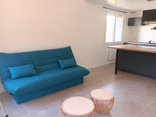 a blue couch in a living room with two stools at Chez Lulu, au pied de la Dolce Via in La Voulte-sur-Rhône
