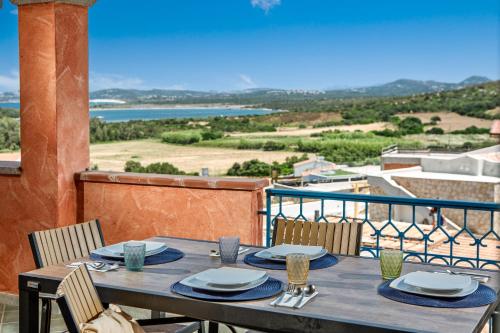a table on a balcony with a view of the ocean at BILANCIA VI 30' Porto Cervo & PRIVATE TERRACE with Sea View in Santa Teresa Gallura