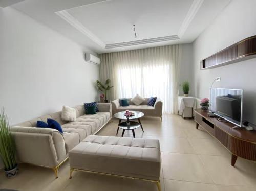 a large living room with couches and a tv at Charmante résidence avec piscine à Monastir in Monastir